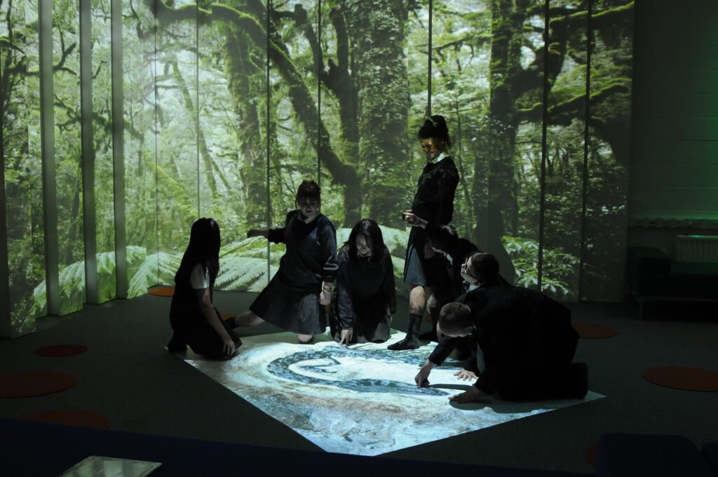 varios niños disfrutan de las proyecciones inmersivas con una proyección interactiva en el suelo