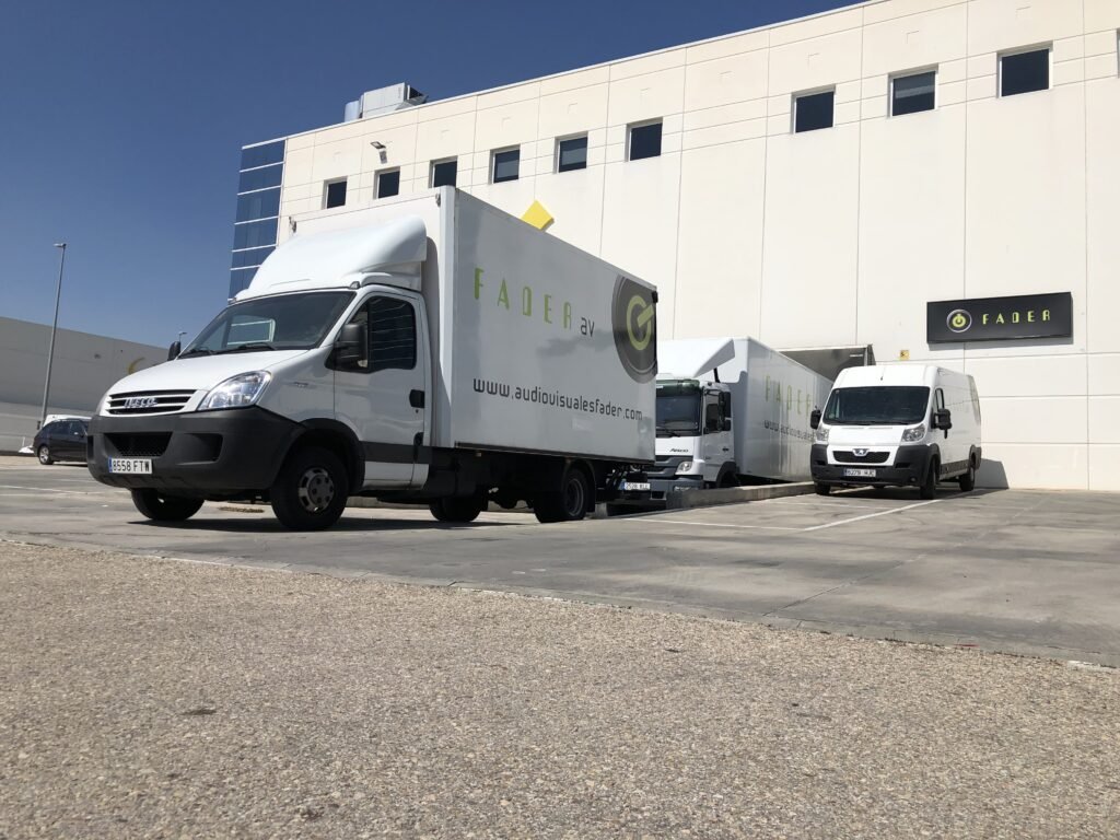 Instalaciones de audiovisuales fader con camiones con el logo en la entrada del edificio