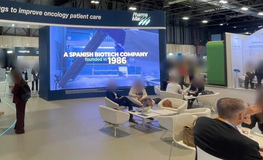 Pantalla LED de gran formato integrada en el stand de PharmaMar frente a la zona de reuniones en IFEMA